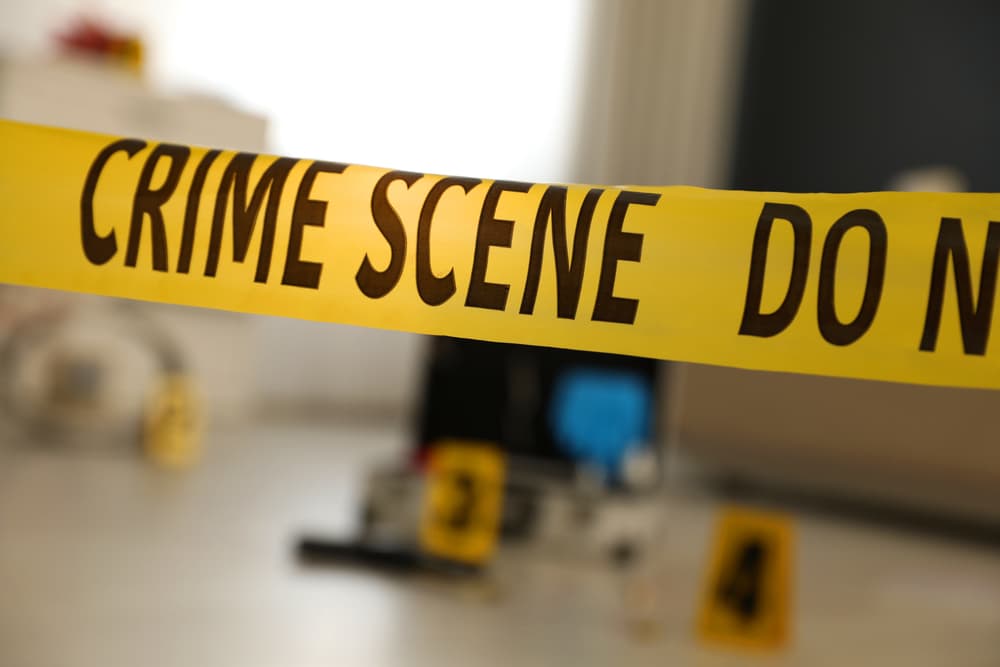 Crime scene with evidences and criminologist case, focus on yellow tape