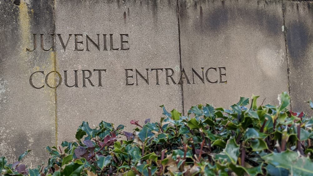 Weathered stone slab sign with the words juvenile Court Entrance 