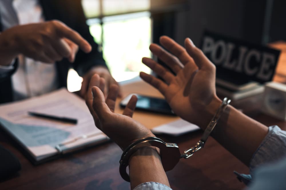 Law enforcement officer interrogating Criminals male with handcuffs in the investigation room Police officer interviewing after committed a crime