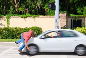 A man that is texting while driving runs over a pedestrian while the Cross the road