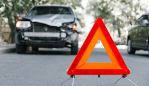 Red emergency stop triangle sign on road in Hit and Run car accident scene.